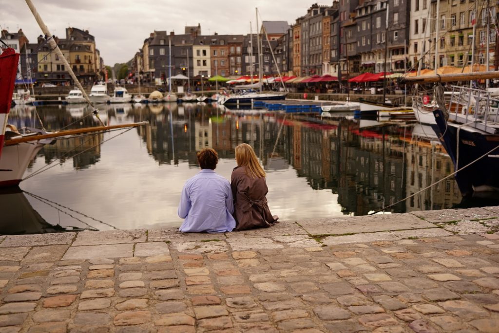 Couple assis sur le port de Honfleur en Normandie