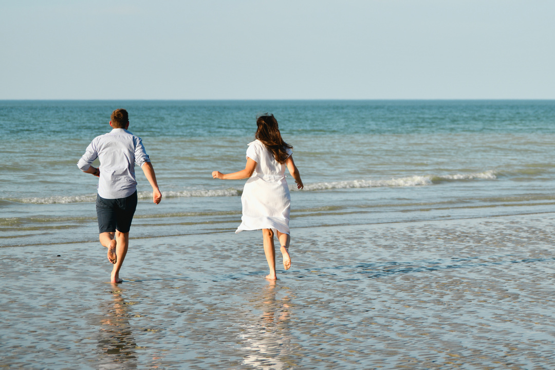 Couple marchant sur le bord d'une plage normande.