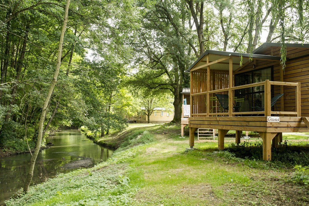 Chalet au bord de la rivière au camping Huttopia Les Châteaux