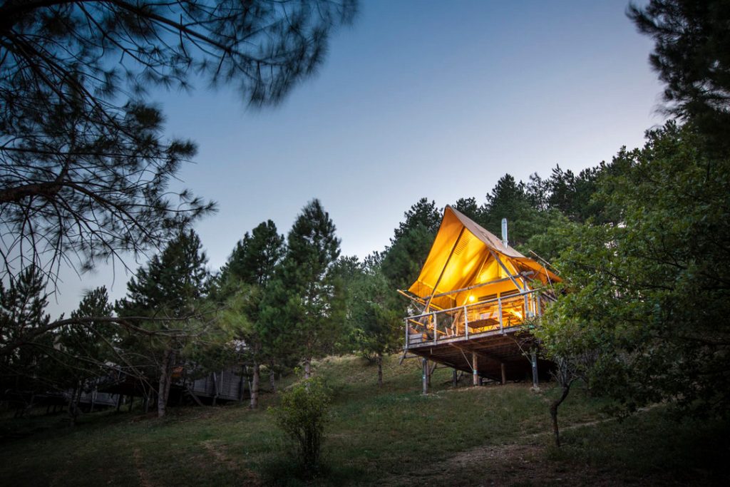 Cahutte à la tombée de la nuit au camping Huttopia Dieulefit
