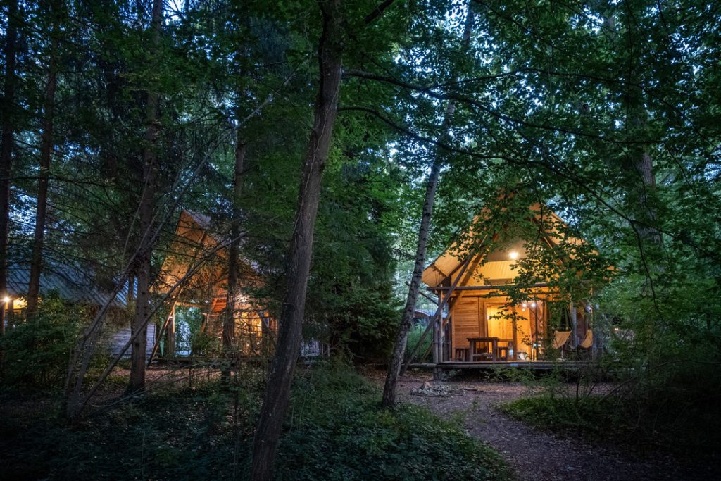 Deux cahuttes au milieu des arbres du camping Huttopia Rambouillet