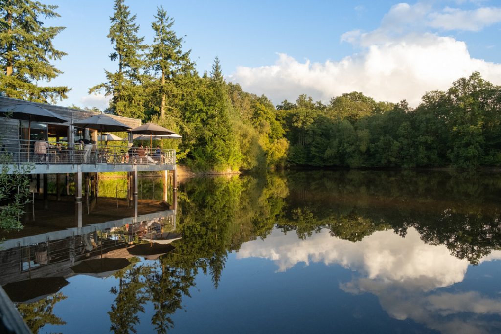 Terrasse du centre de vie du camping Huttopia Senonches surplombant l'étang