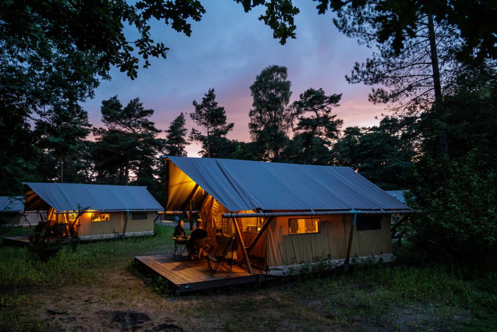 Hébergements toilés à la tombée de la nuit au camping Huttopia De Veluwe