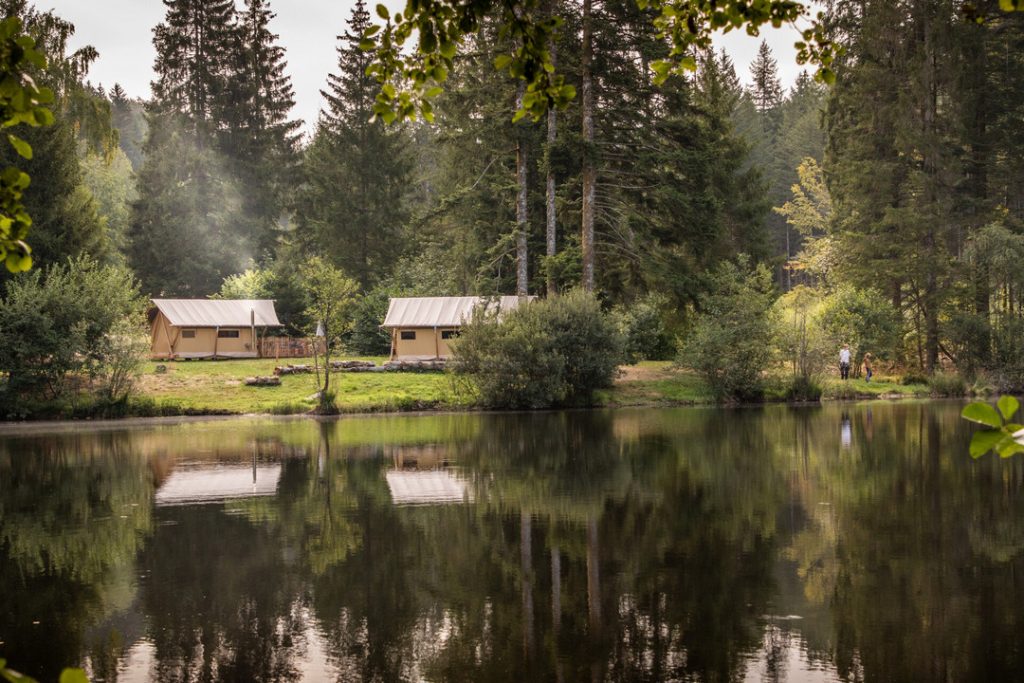 Tentes équipées près de l'étang du camping Huttopia Forêt des Vosges