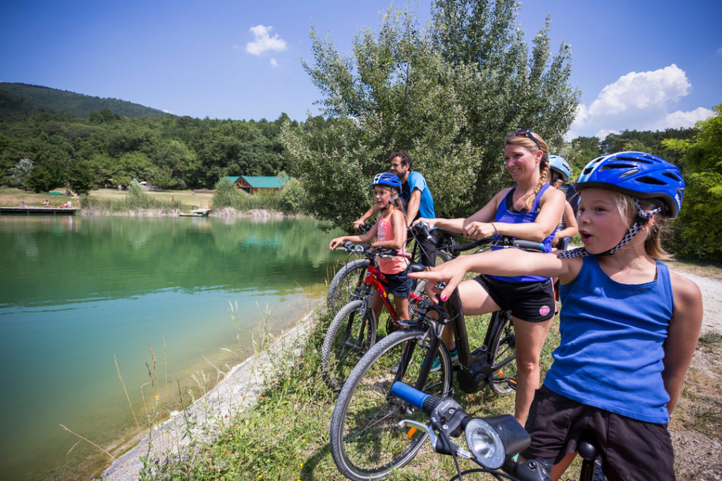 famille qui fait du vélo au départ du camping huttopia dieulefit dans la drôme